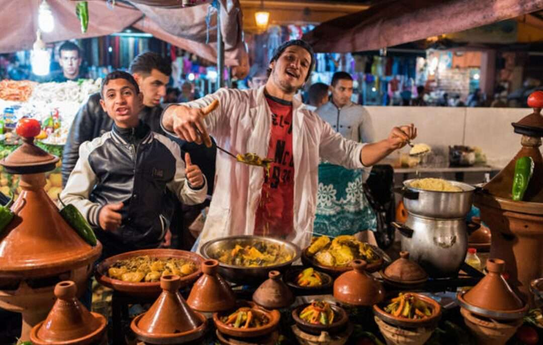 marché marocain animé. cuisinier-vendeur tagine couscous