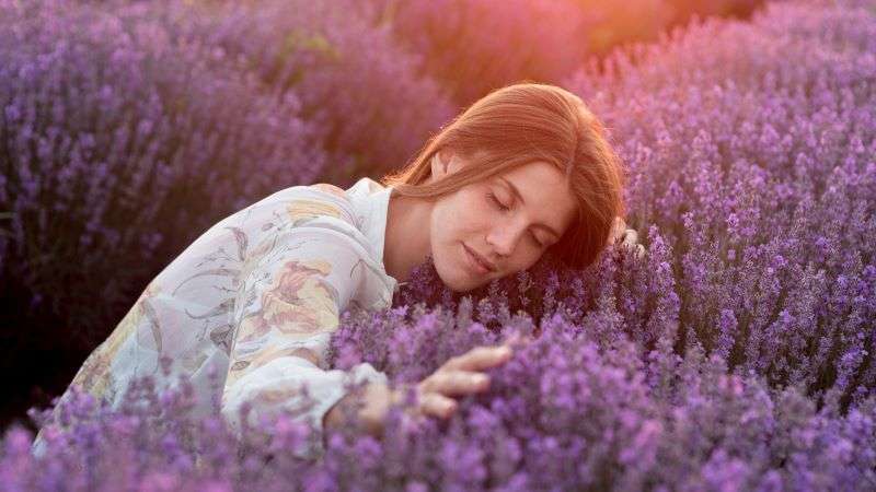 femme touche plante lavande - favorisant sommeil